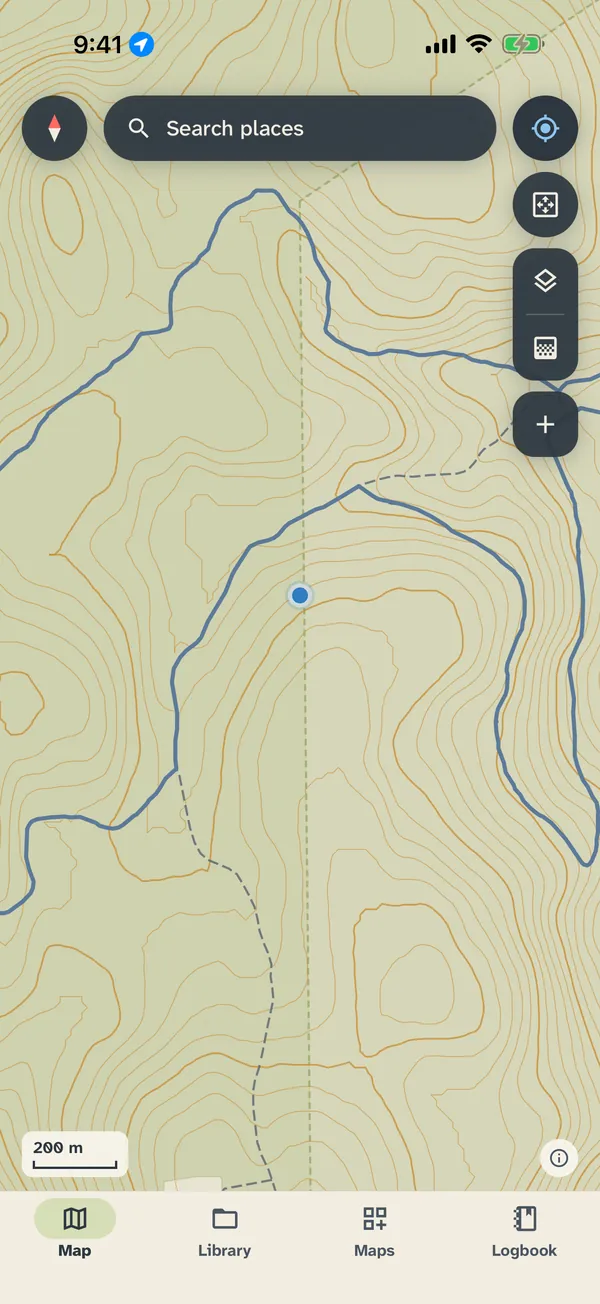 The map screen on mountain terrain: dense contour lines, a dashed trail and a blue dot for your position